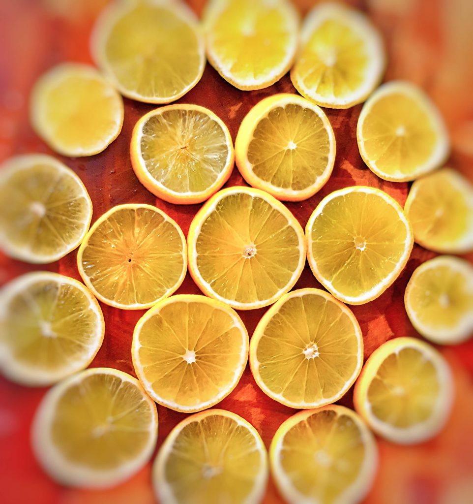 rondels of limes arranged with one in the middle and two circles around one with 6 rondels and the outer one with 13. They are all yellow on a wooden backgorund