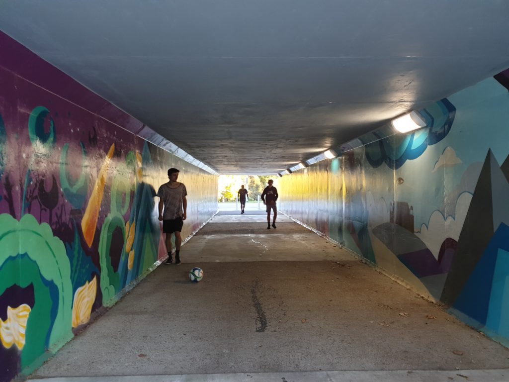 Boys playing football in an underpass